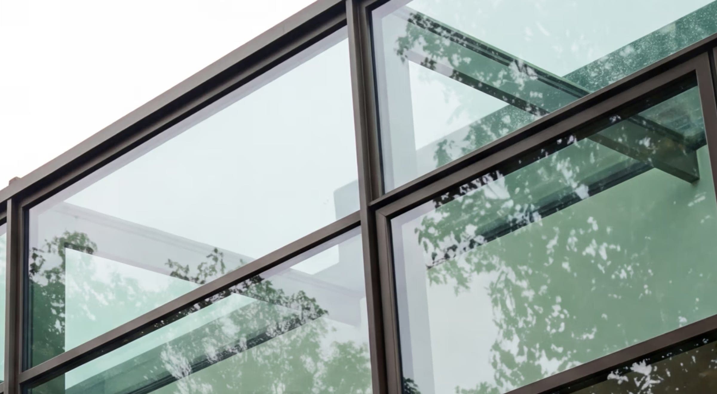 Looking up at a steel-and-glass facade with trees reflected in the panes, from the Clarion architecture template.