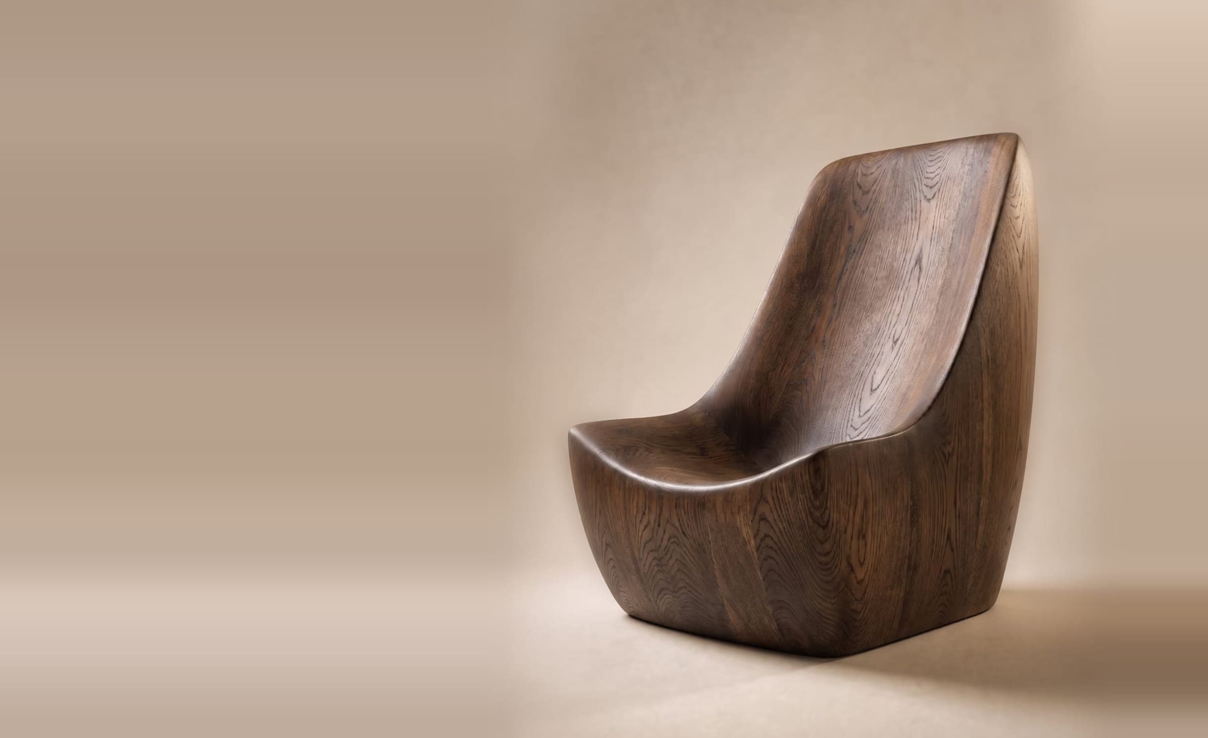 A carved dark-oak lounge chair from the Plinth template, photographed alone on a warm studio sweep.