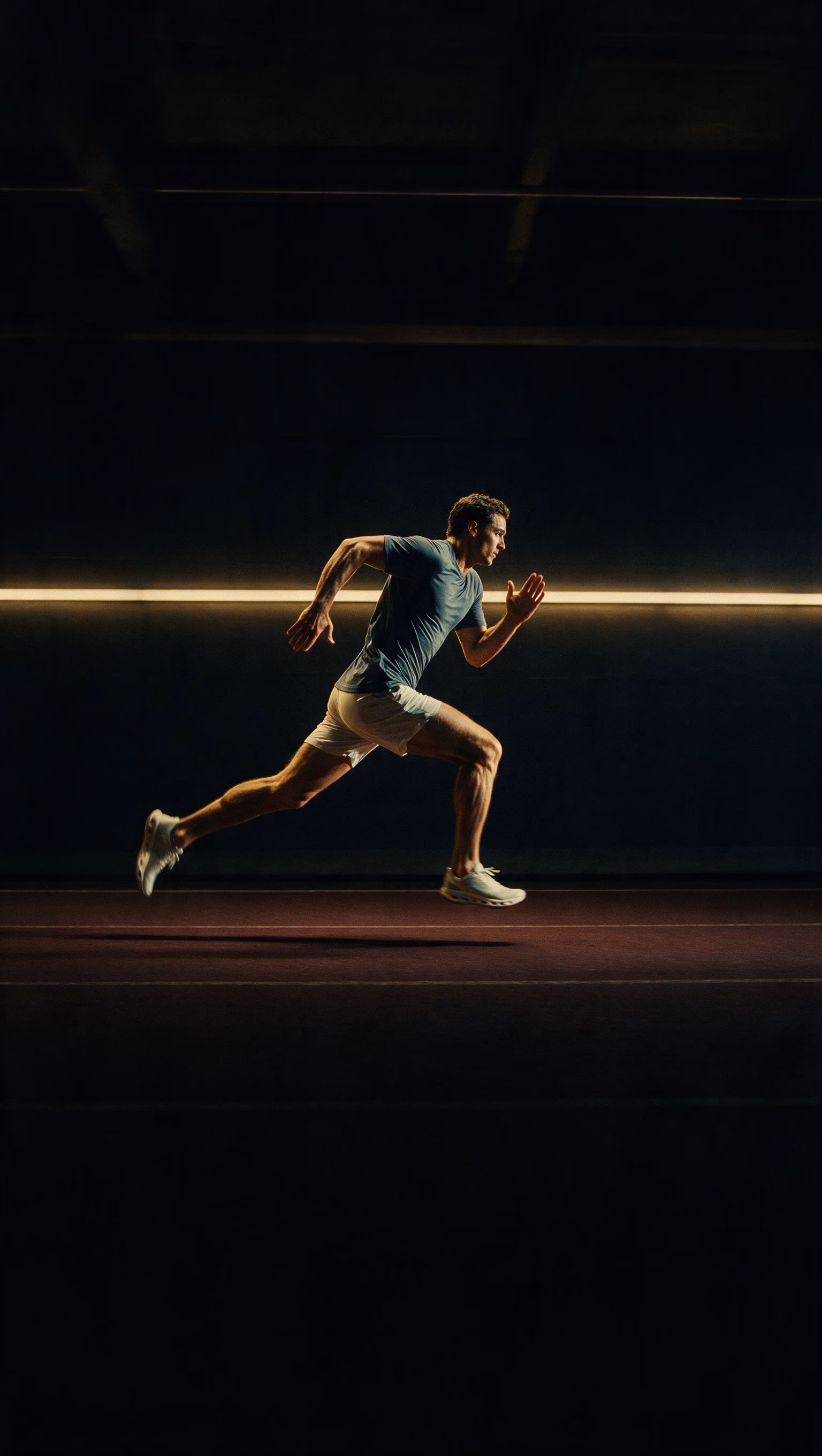 A sprinter mid-stride on an indoor track
