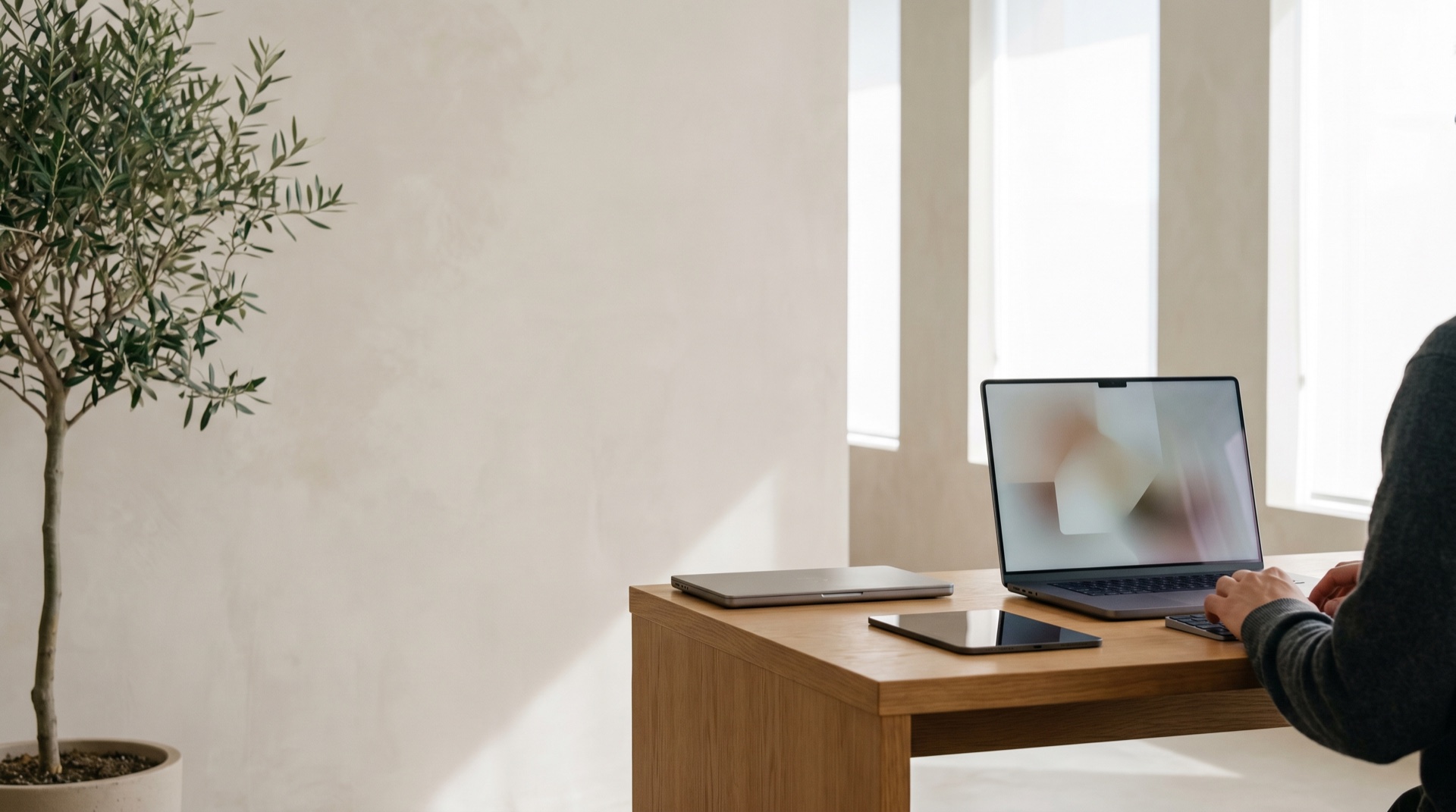 A clean, modern product team workspace in soft daylight, devices and considered detail, calm and premium, generous negative space
