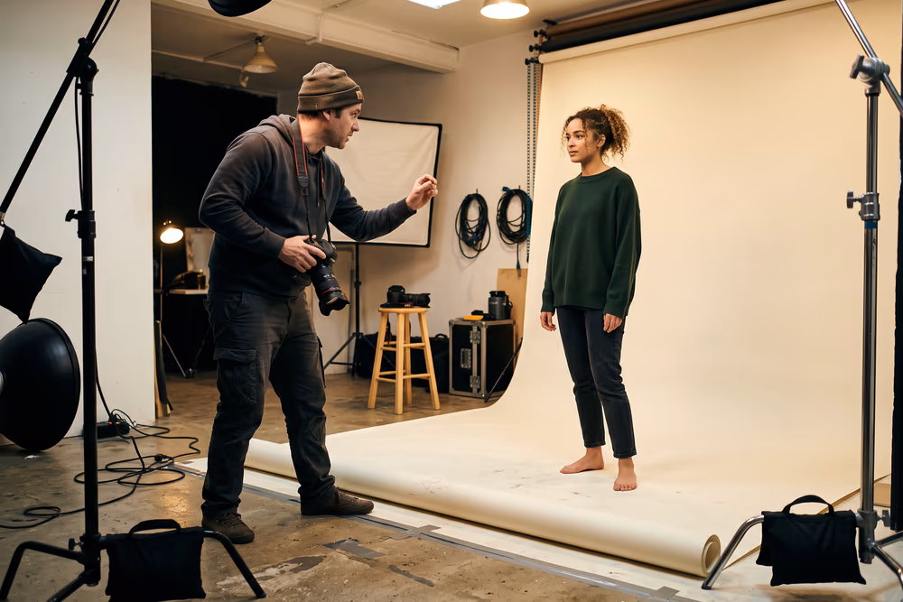 A photographer directing a model on a paper seamless backdrop