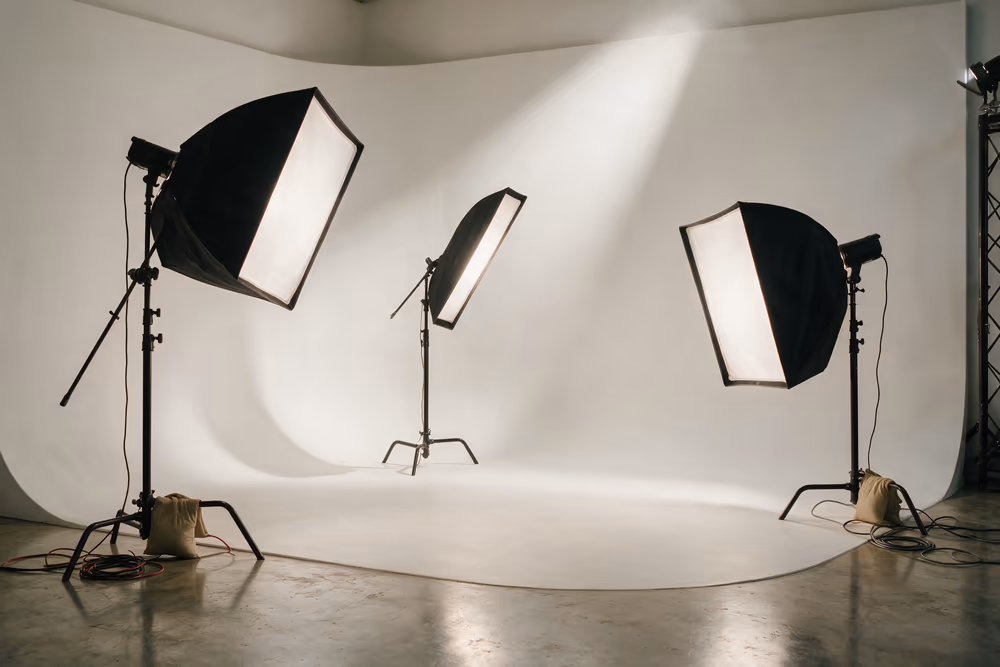 Softboxes on C-stands aimed at an empty white cyclorama